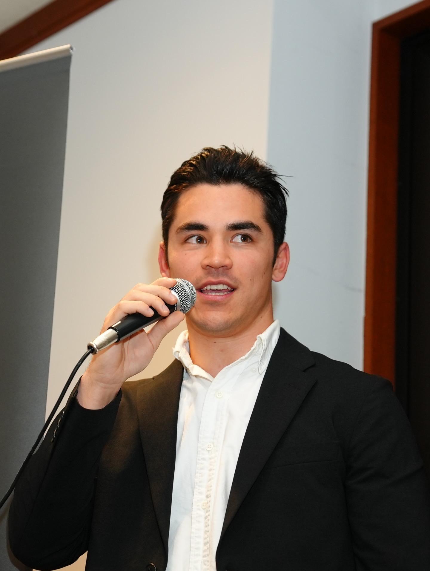 Louis hosting an indoor event with microphone